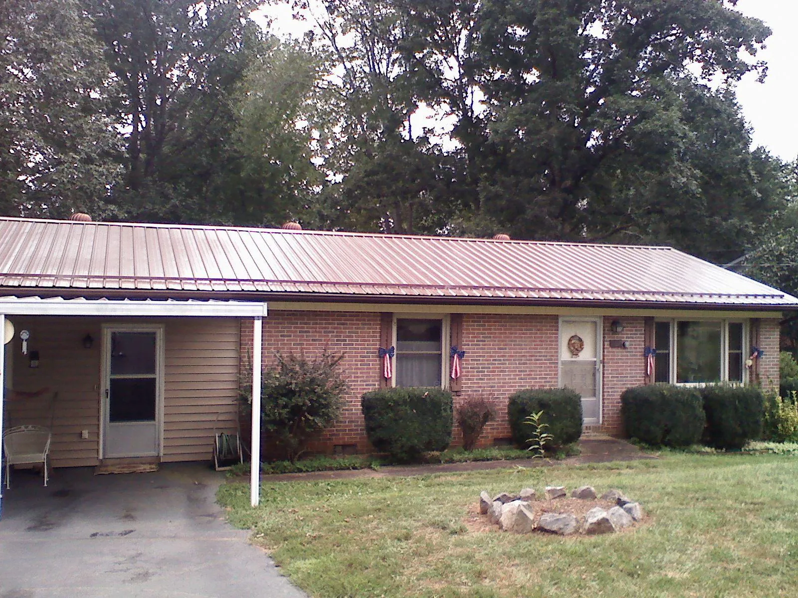 Bronze metal roof and carport on a brick ranch home — Roof Repair work by our crew in Nichols